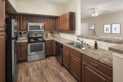 Kitchen with stainless steel appliances and bar-height countertops at Camden Buckingham apartments in Richardson, Tx