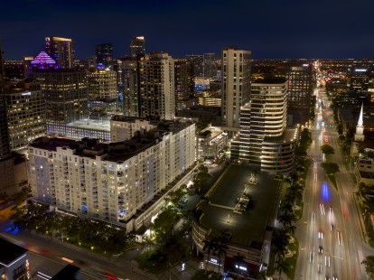 Exterior of Camden Las Olas apartments and E Broward Blvd in Fort Lauderdale, Florida at dusk.