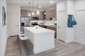 Contemporary interiors kitchen with large islands, white quartz countertops and mocha cabinets
