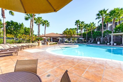 Resort style swimming pool with lounge and dining areas