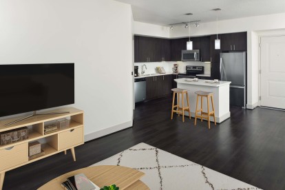 Living room space showing open kitchen concept at Camden Boca Raton apartments in Boca Raton, Florida.