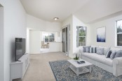 Living room with sliding glass door access to patio vaulted ceiling and carpet flooring