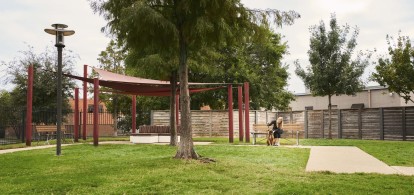 Large fenced dog park with covered seating area