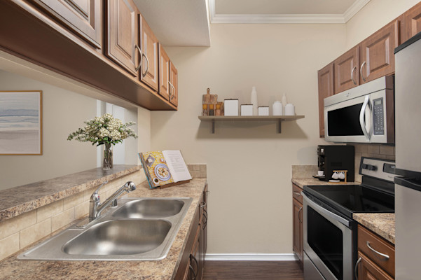Kitchen with stainless steel appliances and bar-height countertop at Camden Legacy Creek