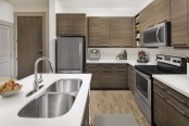 Kitchen with white quartz countertops and stainless steel appliances at Camden Lincoln Station Apartments in Lone Tree, CO