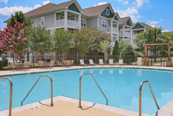 Swimming pool with lounge seating and building in the background at Camden Franklin apartments in Franklin, TN