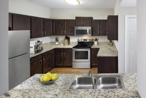 Traditional style kitchen with granite-style countertops, stainless steel appliances, and wood-look flooring