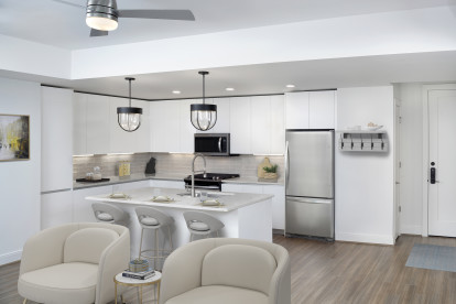 White contemporary open-concept kitchen and living room with hardwood-style flooring throughout