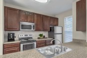 Kitchen with granite style countertops stainless steel appliances and tile backsplash