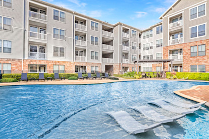 Resort-style swimming pool with water features and sun loungers at Camden Heights Apartments in Houston, TX