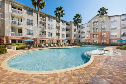 Resort-style swimming pool with water features and sun loungers at Camden Heights Apartments in Houston, TX