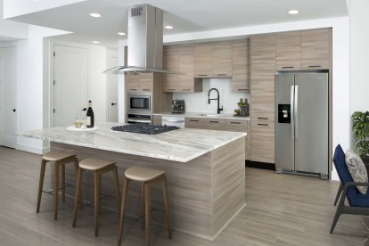 Warm modern finishes kitchen with quartz countertops stainless steel appliances and large kitchen islands