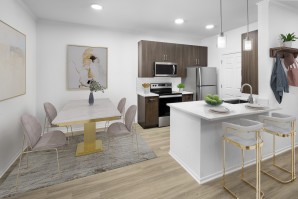 Camden San Marcos Apartments Scottsdale AZ open concept dining area with woodlike flooring near kitchen with stainless steel appliances and white quartz countertop with space for barstool seating