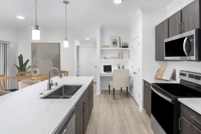 Renovated kitchen with white marbled countertops and white backsplash at Camden Panther Creek apartments in Frisco, Tx