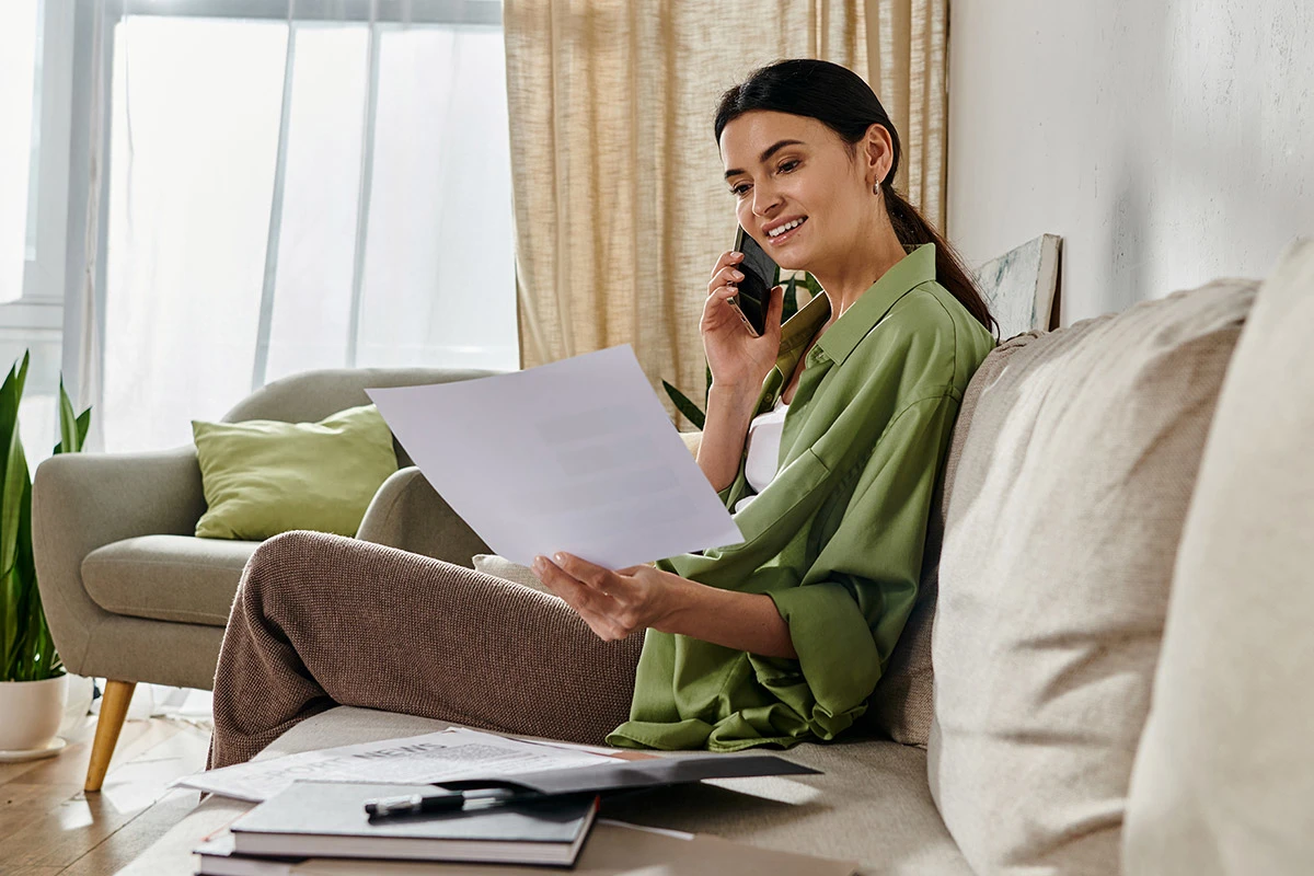 Woman on the phone, looking at invoice or paperwork