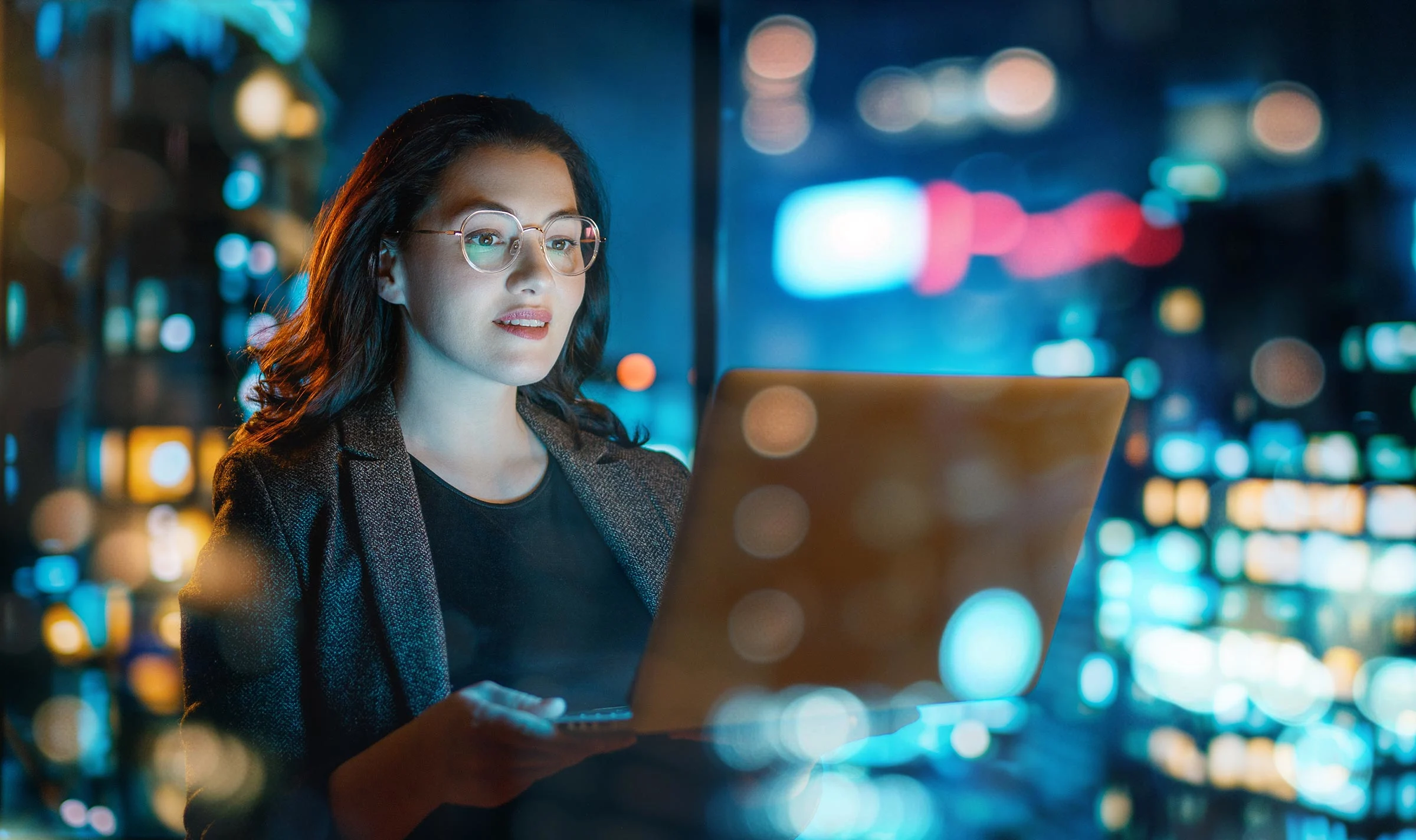 business woman working on laptop night city office