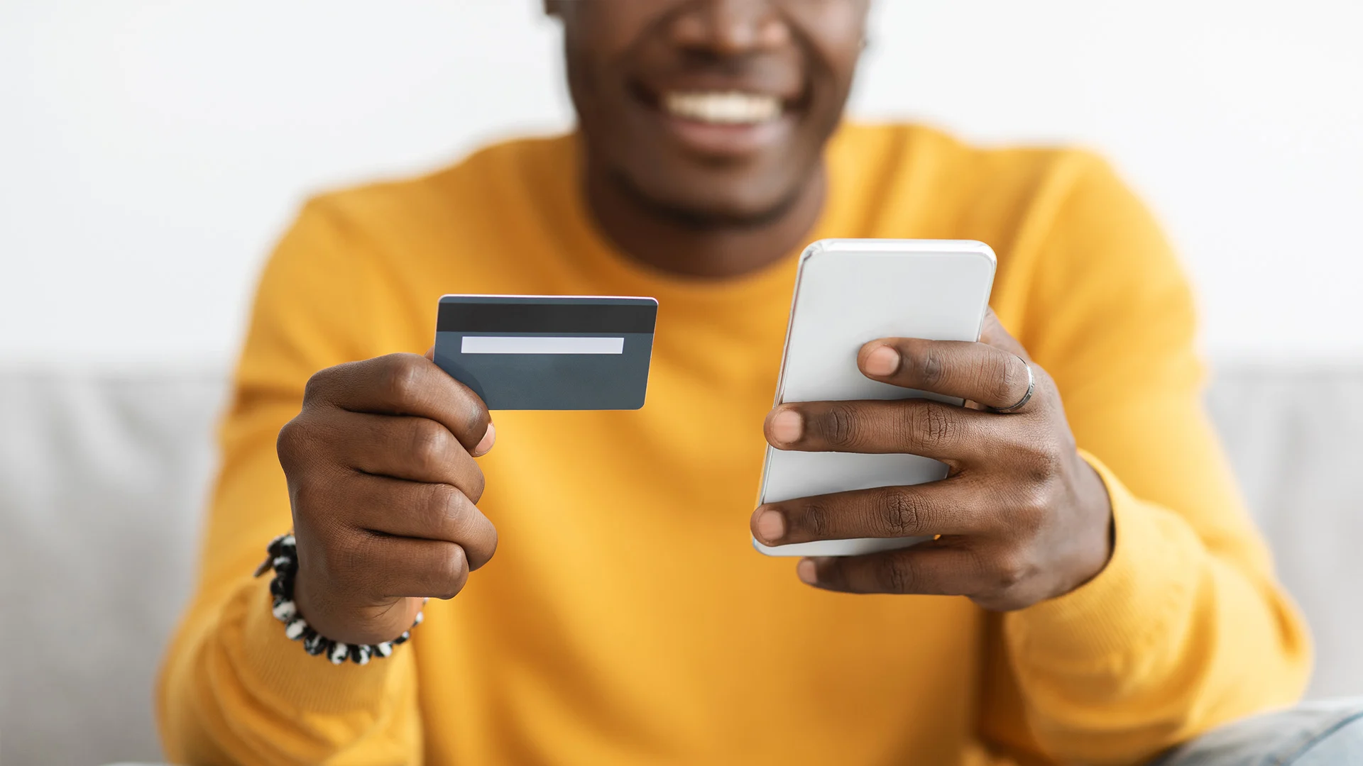 African guy holding cellphone and credit card