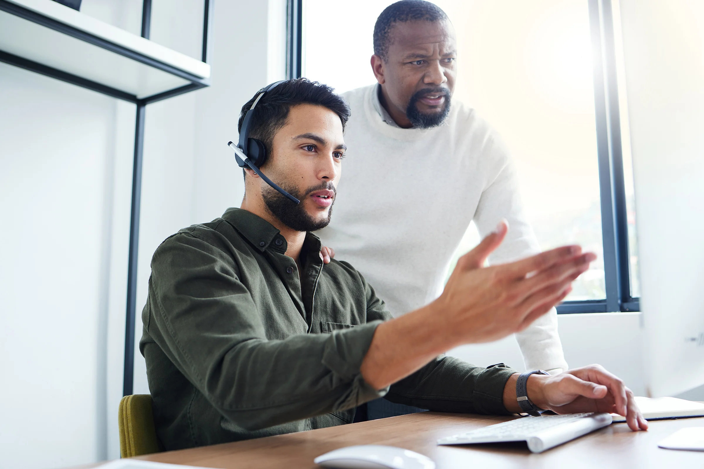 shot of young male call center worker receiving assistance