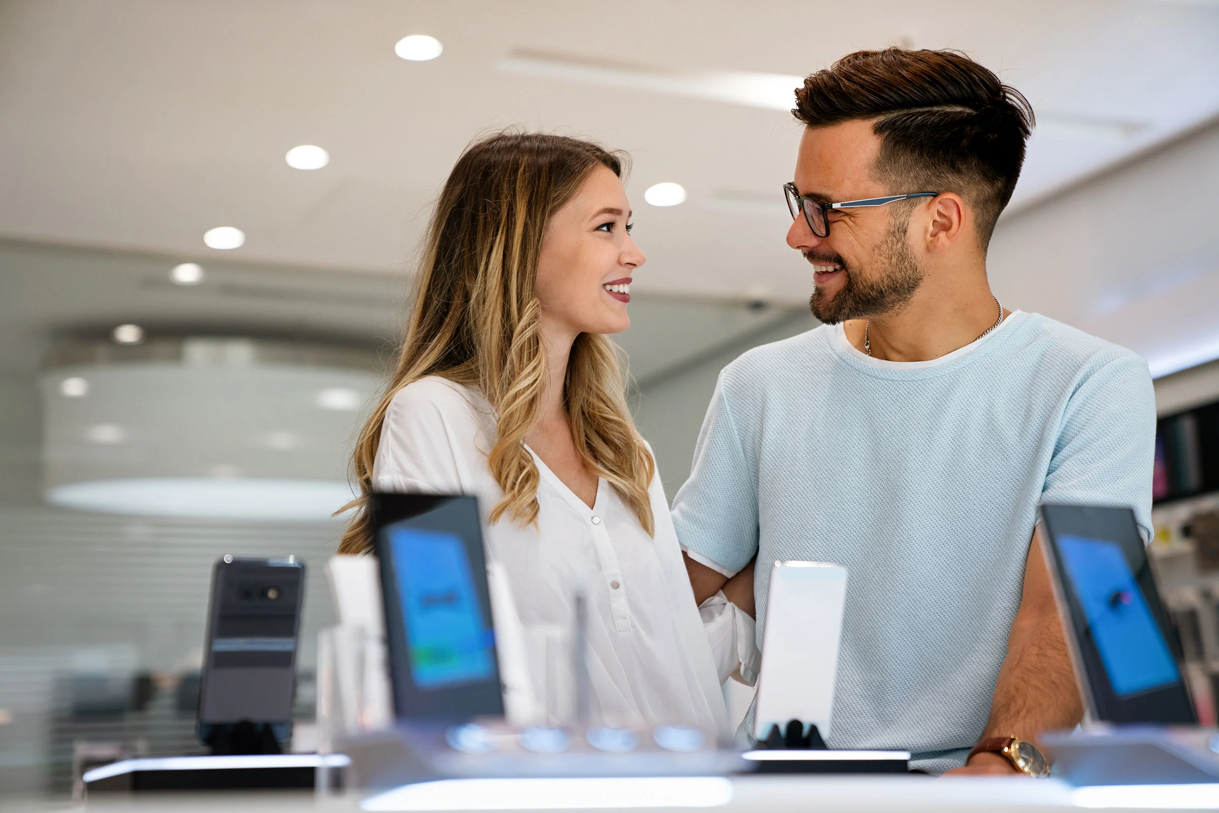 Happy young couple shopping for phones
