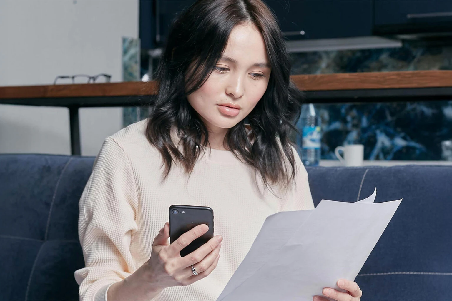 Young woman paying bills on phone