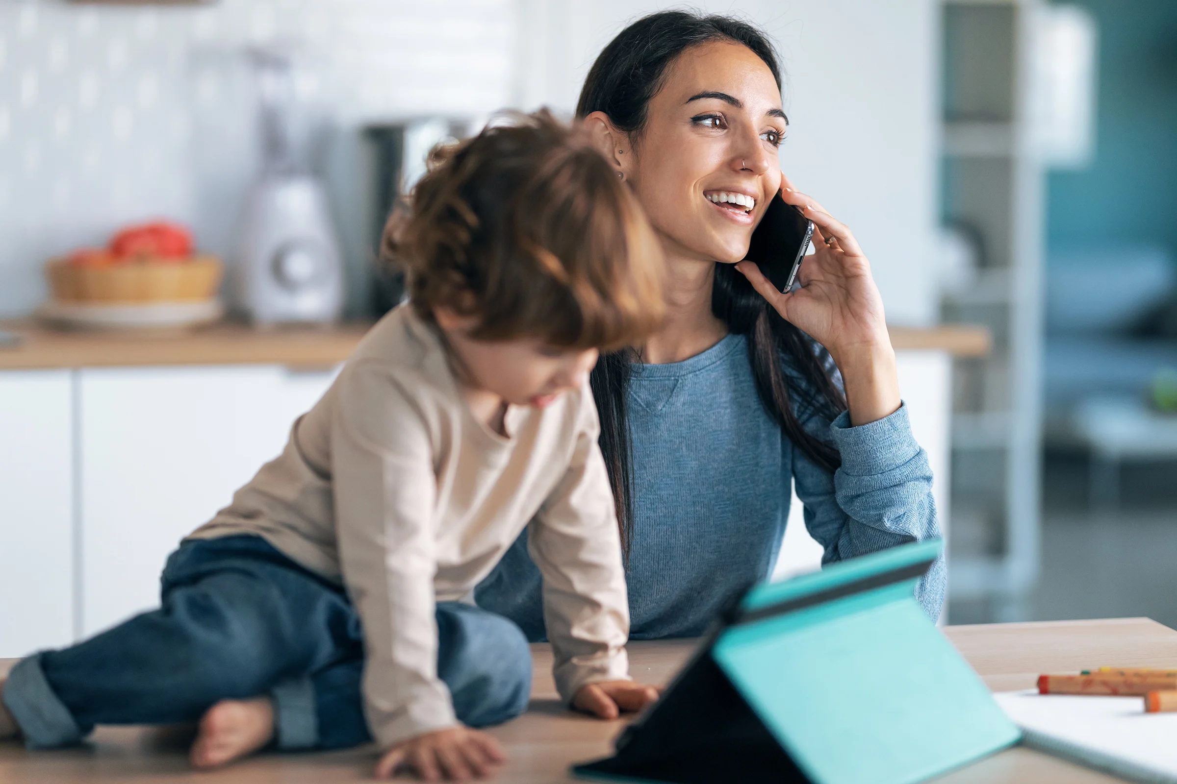 smiling mother and her son watching cartoons while she is on the phone
