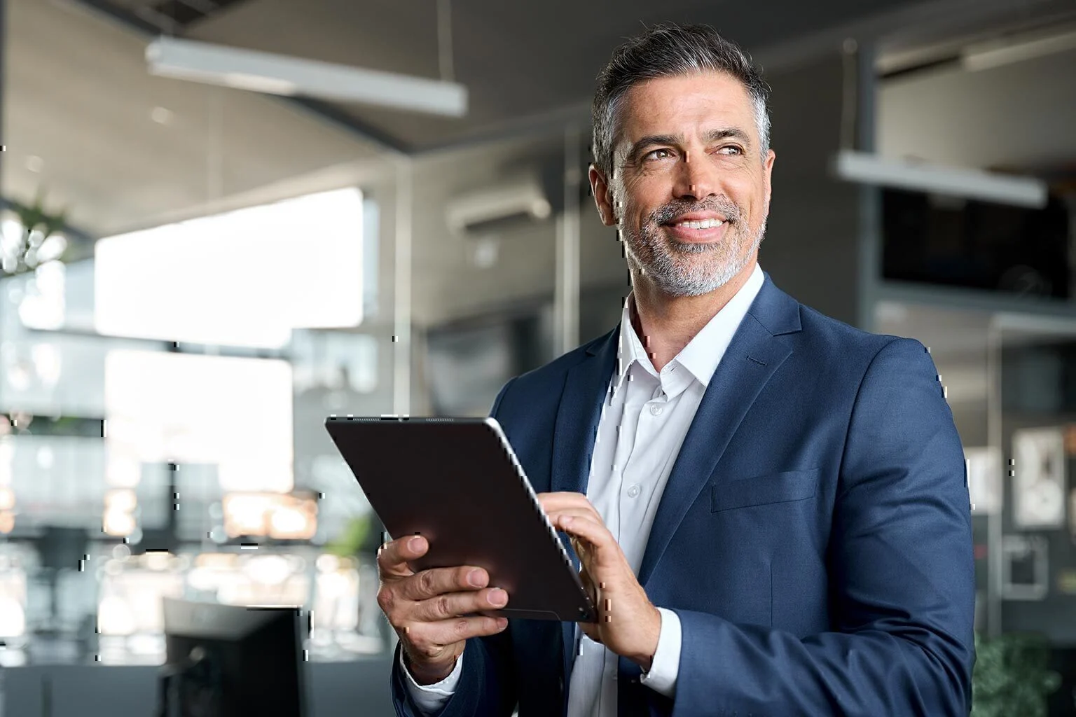 Happy mature business man executive wearing suit in office using tablet