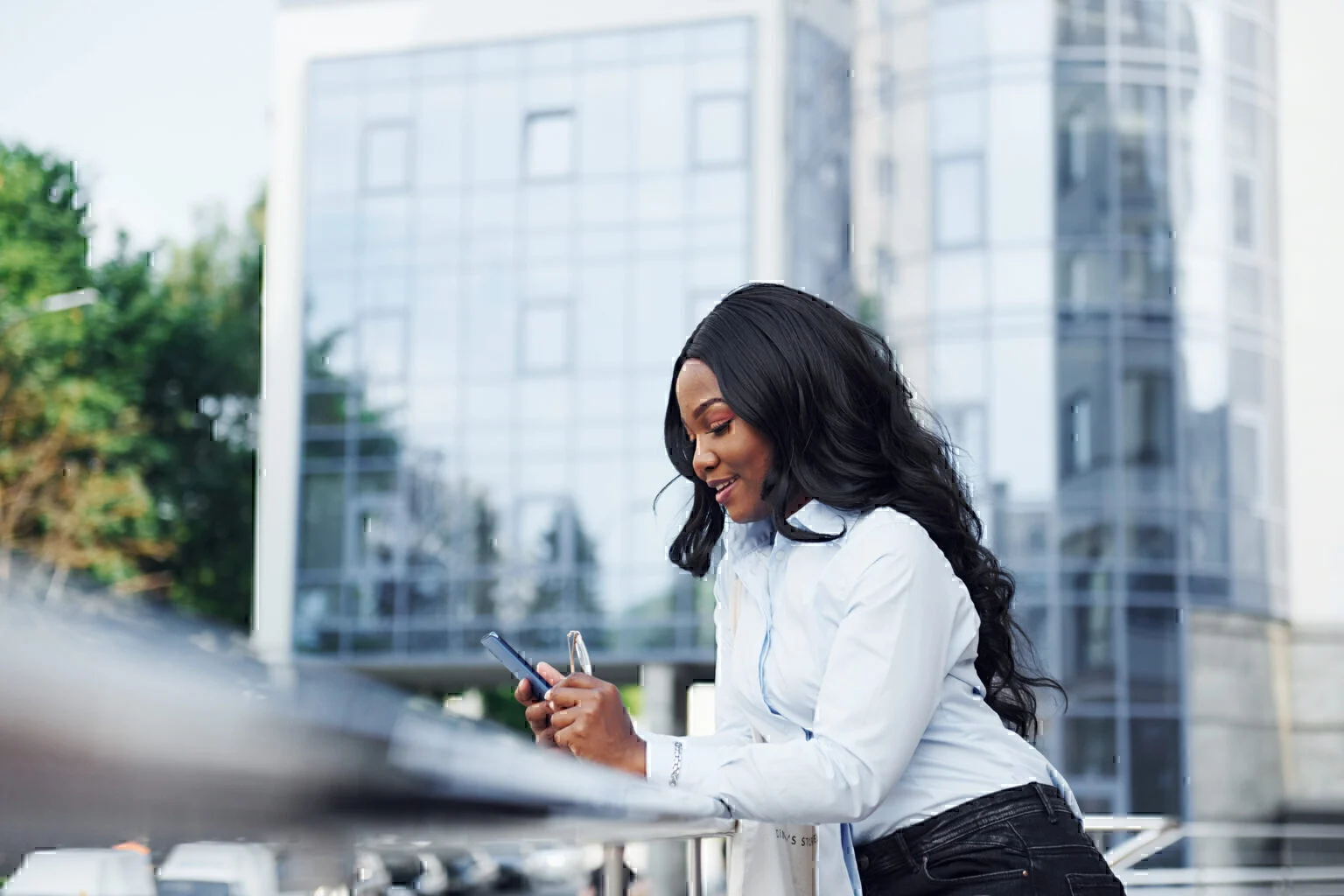 young african american woman in white shirt on phone outdoors