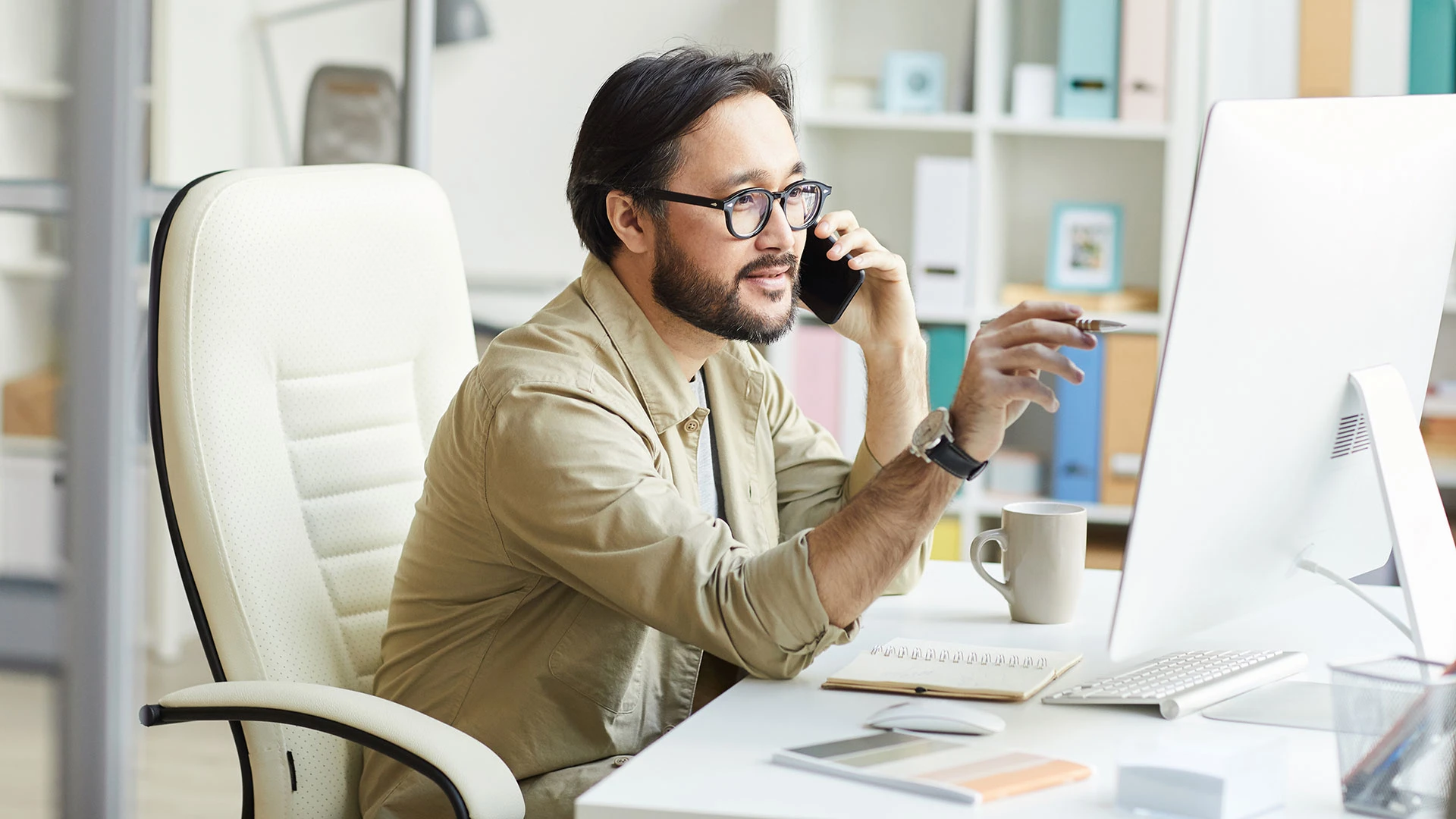 Asian programmer talking to customer on the phone