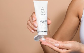 Alpha H Liquid Gold Skin Renewal Wash - product bottle is held in hand while small about is poured onto fingertips - 670 x 427