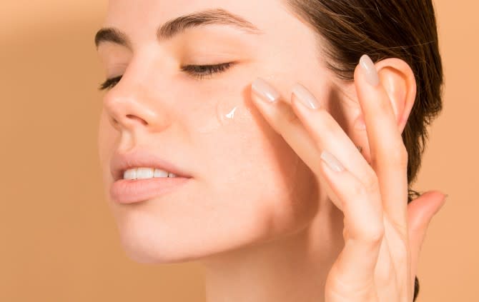 Dermalogica Overnight Clearing Gel - woman looks down to the side as she applies clear gel to her cheek using middle finger - 670 x 423