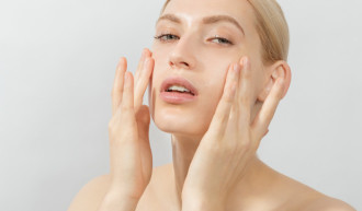 Best Anti-Aging Routine for Dry Skin - Woman in front of white background with her fingers touching her cheeks - 700 x 410
