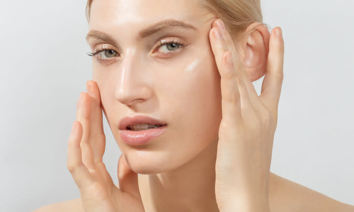 The Best Anti-Aging Routine for Dry Skin - woman holds skin near eyes - 700 x 420