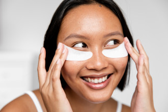 Best under eye masks - young woman is smiling with under eye masks on - 1200 x 800