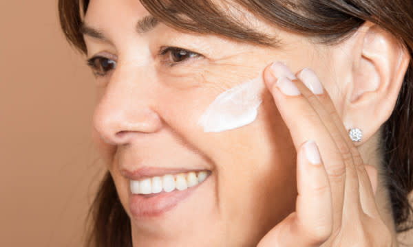 Alpha-H Liquid Gold 24 Hour Moisture Repair Cream - woman applying cream to cheek using fingertips - The Best Wrinkle Creams - 600 x 360