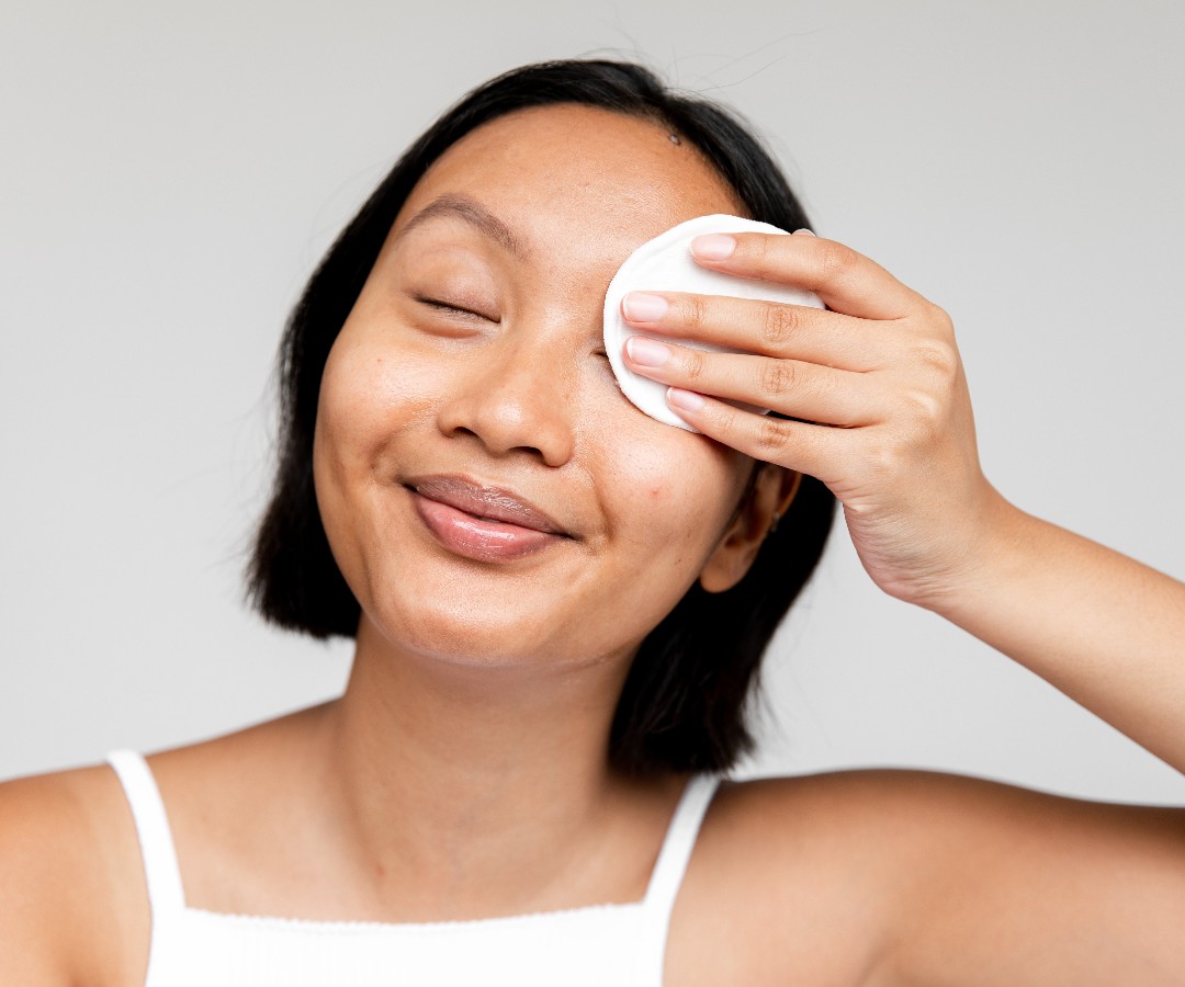 Best Makeup Removers for Oily Skin_woman wiping cotton pad over her eye_1080x900