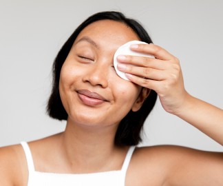 Best Makeup Removers for Oily Skin_woman wiping cotton pad over her eye_1080x900