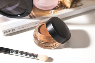 MAC Cosmetics Pro Longwear Paint Pot Groundwork - product jar sits with the lid slighty off next to a makeup brush and a magazine - 670 x 449