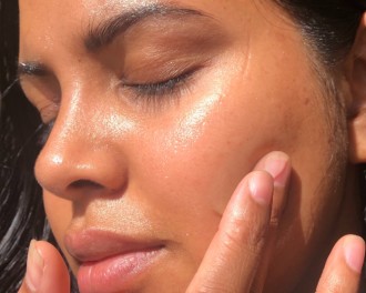 Best Vegan Skin Care for Acne Prone Skin_a close up of a woman applying serum to her cheek