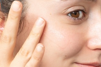 Murad Skincare Eye Serum - close up of woman applying serum along her upper cheek bone - 1080 x 720