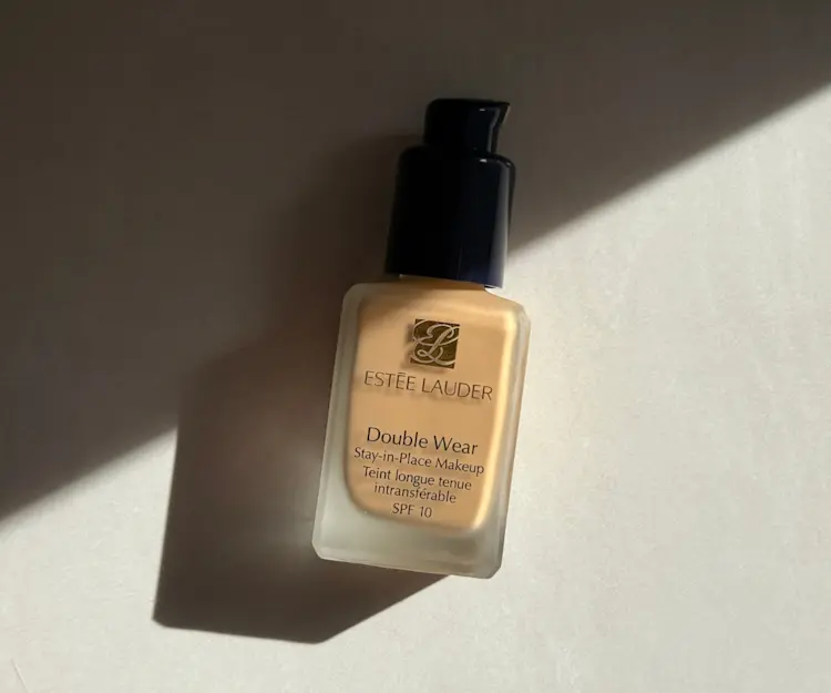A bottle of the ESTEE LAUDER Double Wear foundation against a plain white wall.