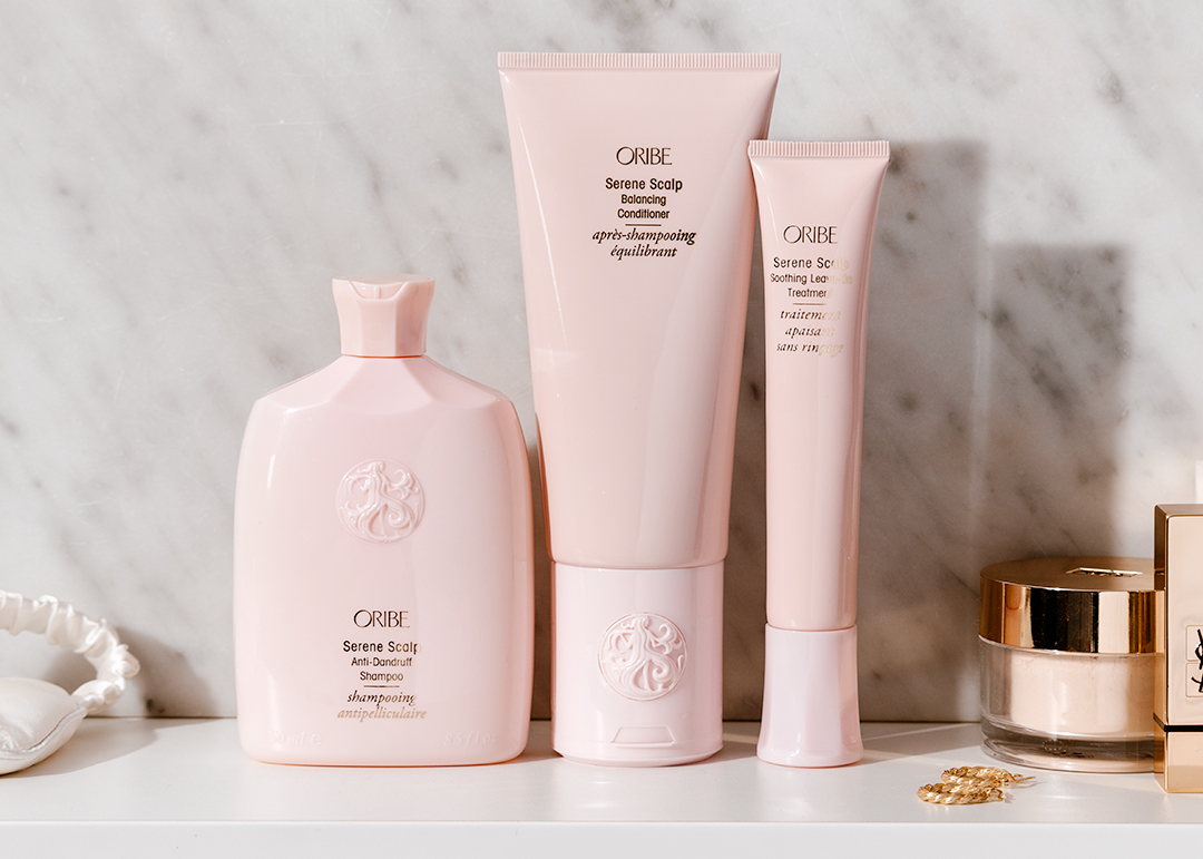 Oribe Serene Scalp Range - Adore Beauty haircare  - three pink bottles of shampoo, conditioner and treatment standing on bathroom counter - 1080 x 771
