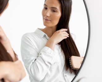 brush for straight hair_woman brushing her long dark hair in the mirror_1000x800