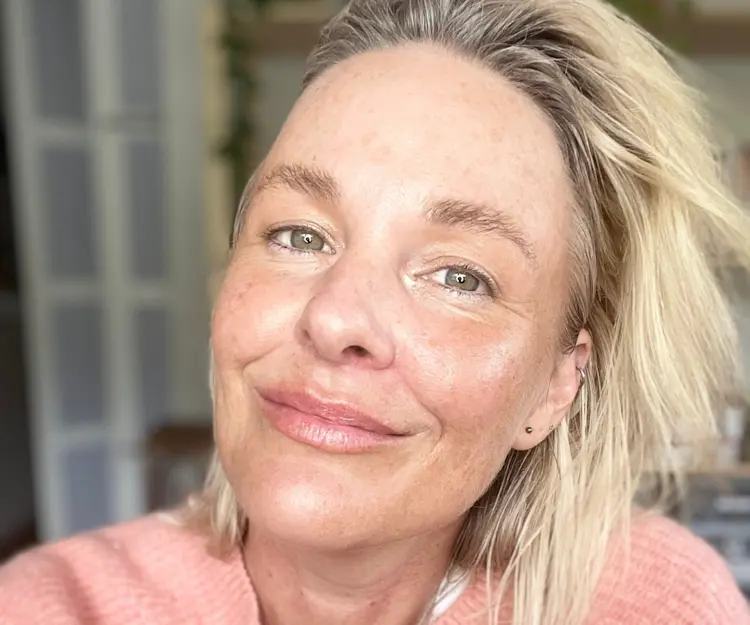 Middle-aged woman with blonde hair and no makeup.