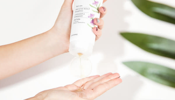 Green People Irritated Scalp Shampoo - one hand holds bottle and squeezes shampoo out onto palm of other hand -The Best Organic Shampoos and Conditioners - 600 x 343