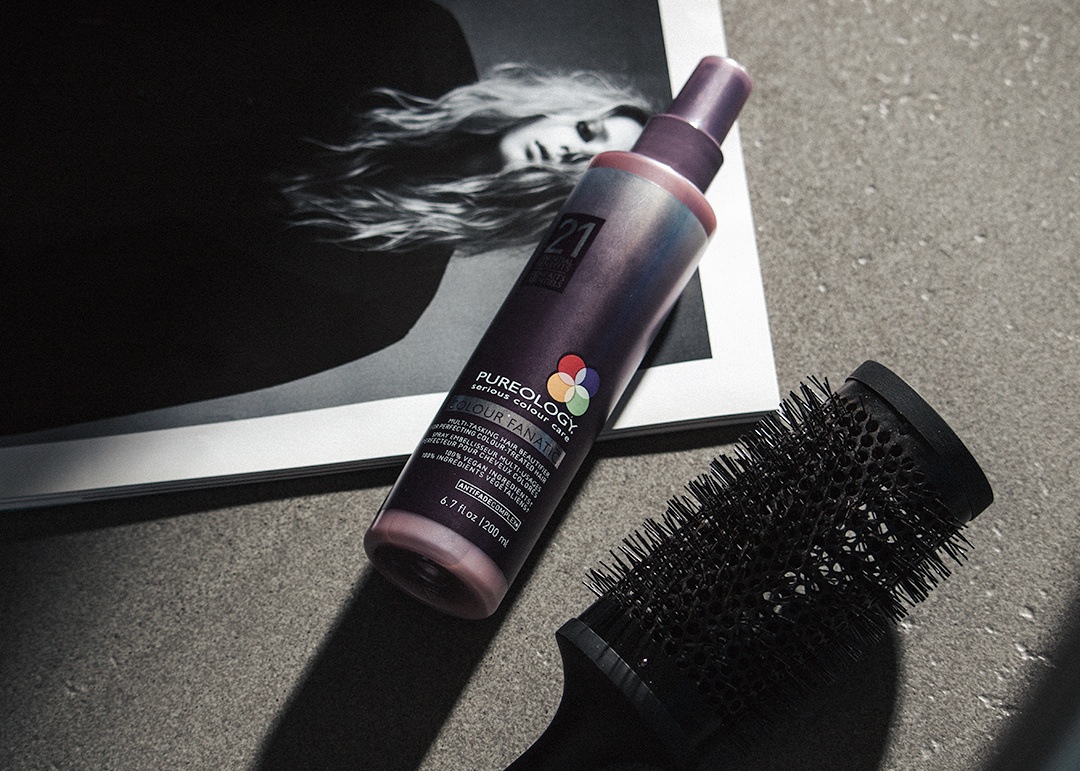 Pureology Colour Fanatic  - flat lay of product bottle on a fashion magazine next to a circular hair brush - 1080 x 771