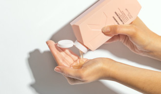 KEVIN.MURPHY Plumping.Wash - one hand hold bottle while pouring product into the palm of other hand - 700 x 410