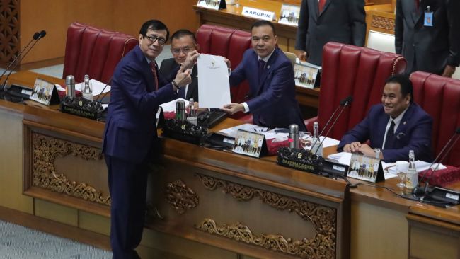 Indonesian Law and Human Right Minister Yasonna Laoly and Deputy House Speaker Sufmi Dasco Ahmad ratifying the country's new criminal code.