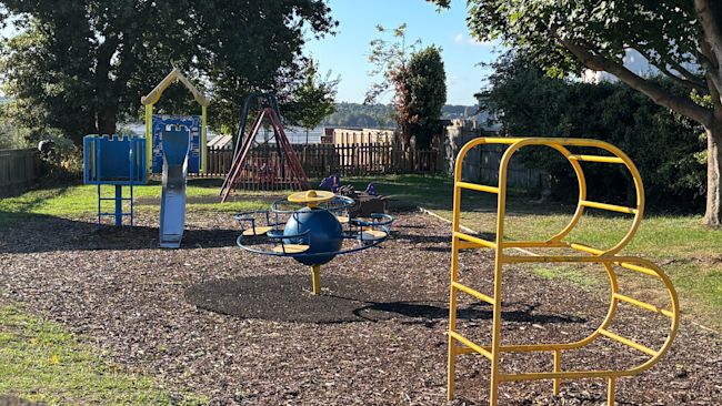 A children's playground with climbing frames and slides.