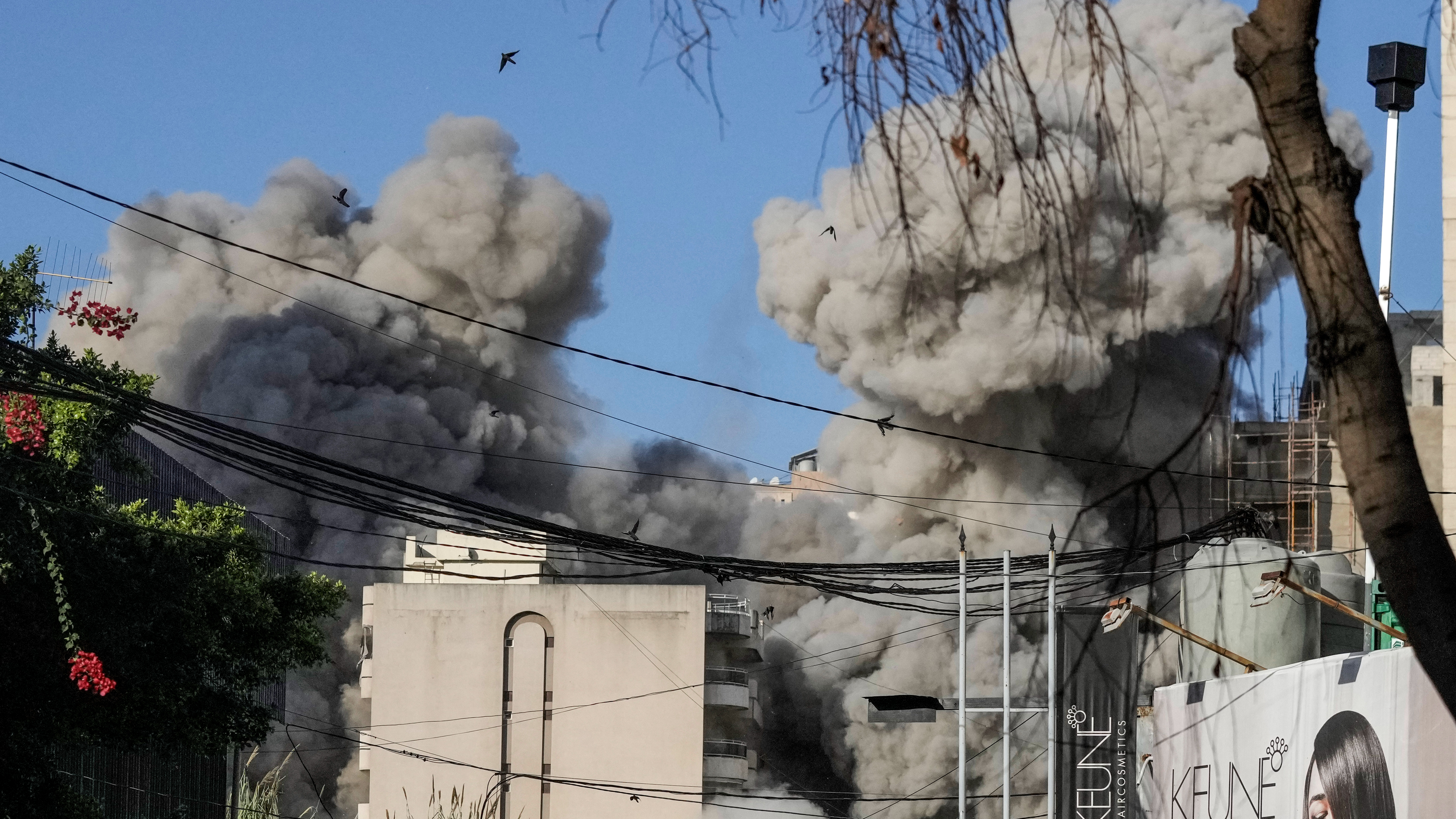Smoke rises from a building collapsing after it was hit by an Israeli airstrike in Chiyah, south of Beirut, Lebanon.