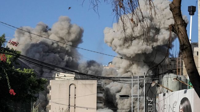 Smoke rises from a building collapsing after it was hit by an Israeli airstrike in Chiyah, south of Beirut, Lebanon.